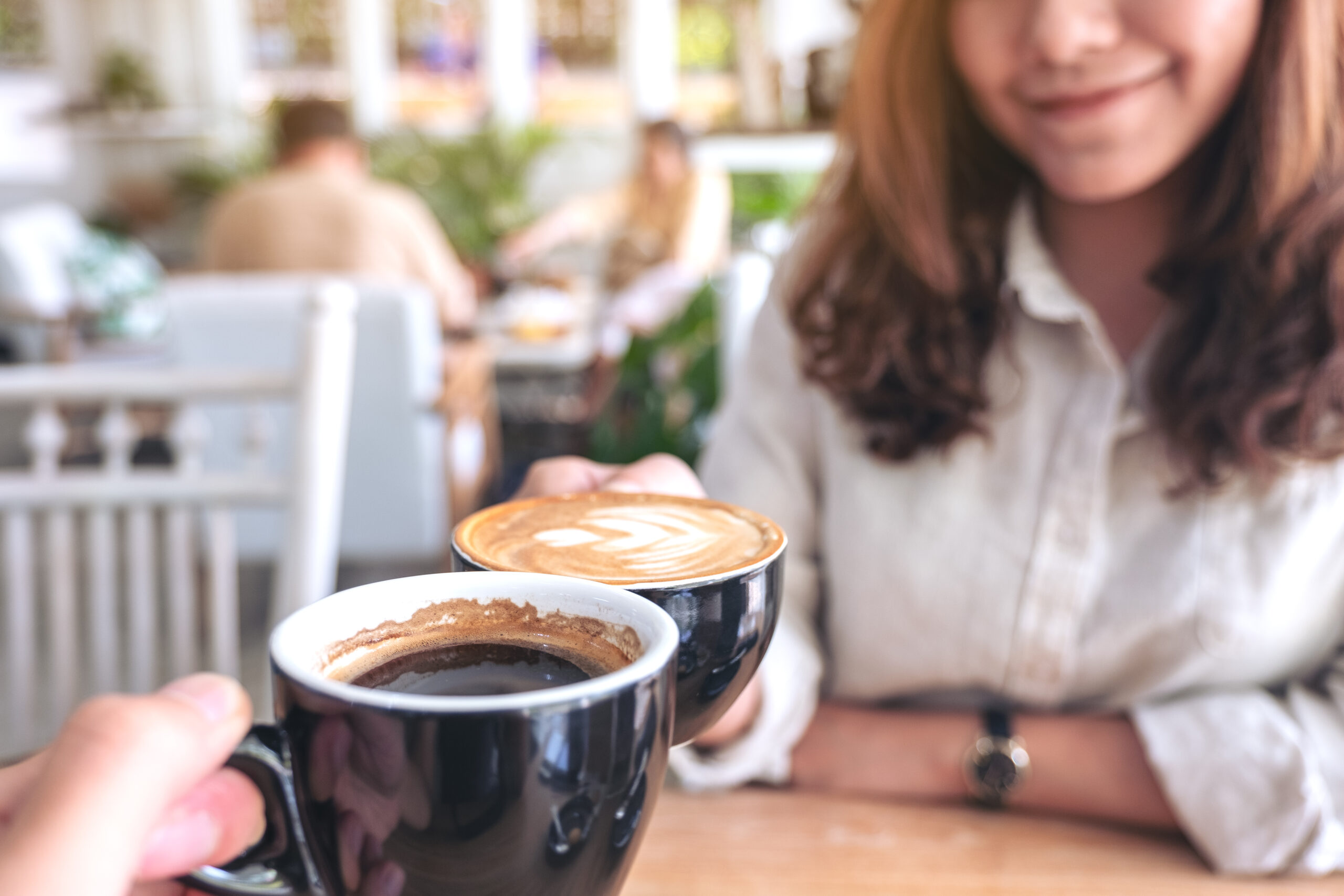 Close Up Image Of A Man And A Woman Clinking Two Coffee Mugs On