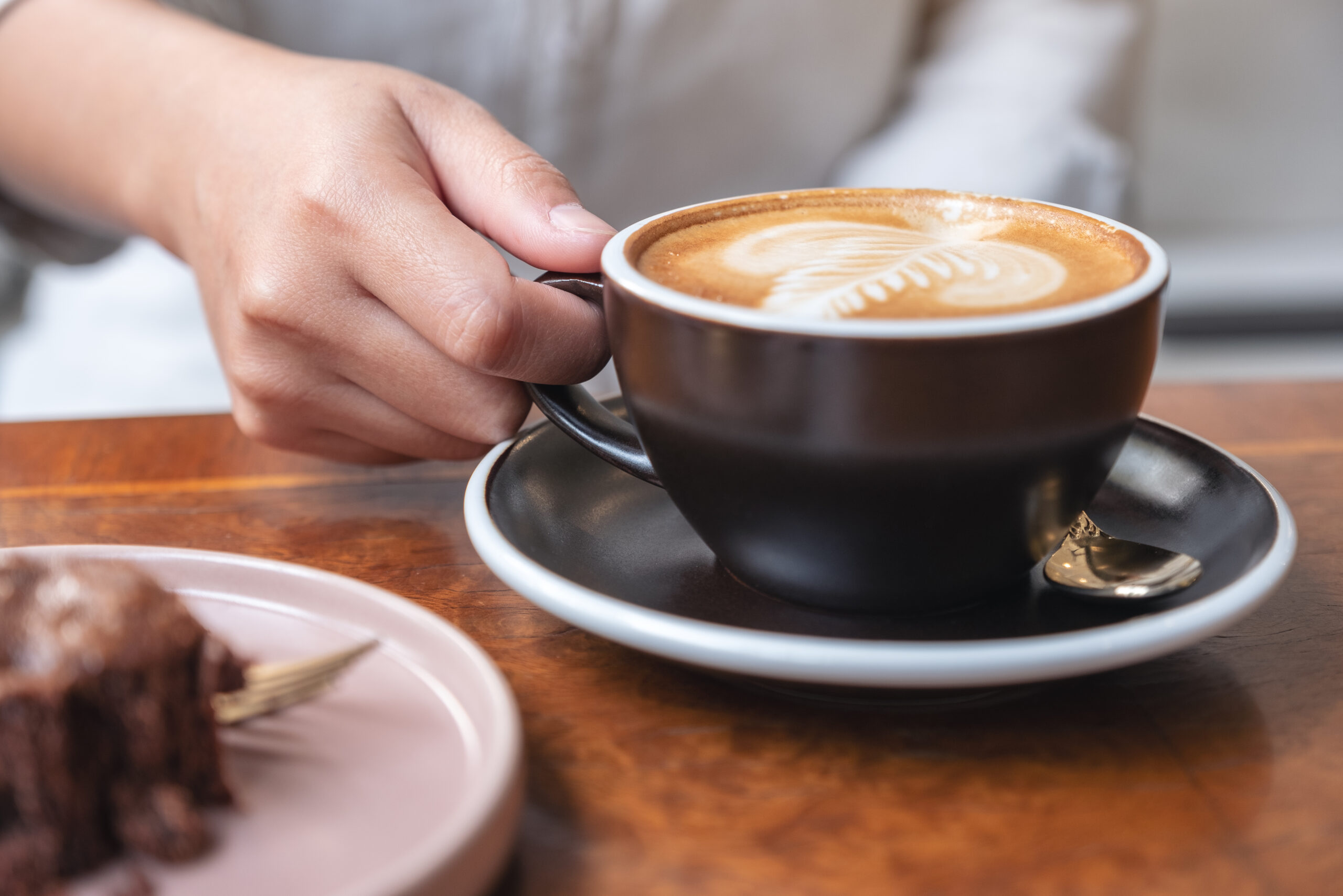 Closeup Image Of A Womans Hand Holding And Drinking Hot Latte C