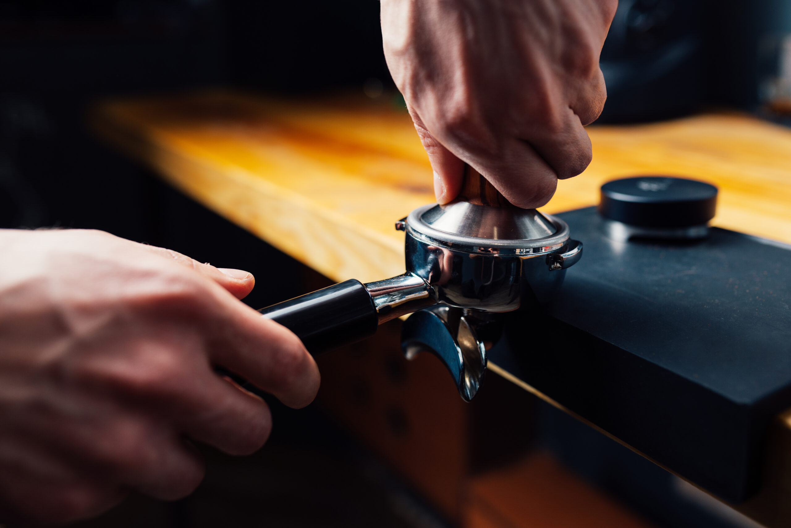 Tempering Coffee In Portafilter On A Dark Background