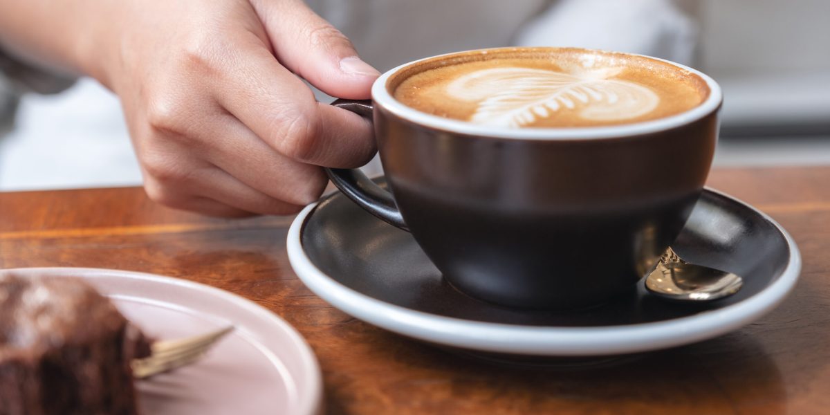 Closeup Image Of A Womans Hand Holding And Drinking Hot Latte C