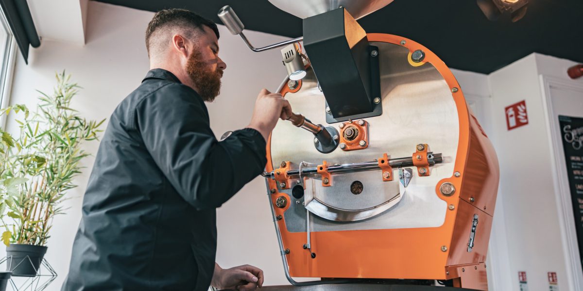 Professional Barista Operating Modern Coffee Bean Roasting Machine